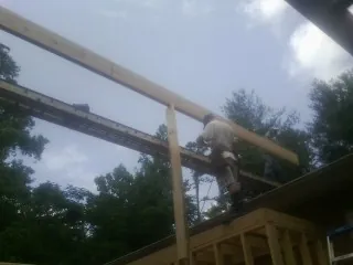 Carpenter setting a ridge beam over a new addition frame — Ice Dam Removal by Roofing Brothers in Crum Lynne