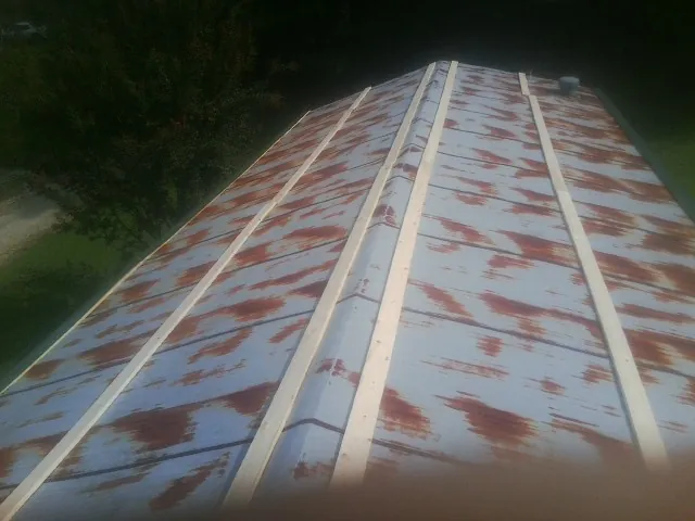 Rusted metal roof panels with new wood purlins before replacement — Storm Damage Roof Repair in Crum Lynne by Roofing Brothers