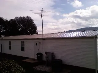 New metal roof on a single wide mobile home with a TV antenna in Crum Lynne