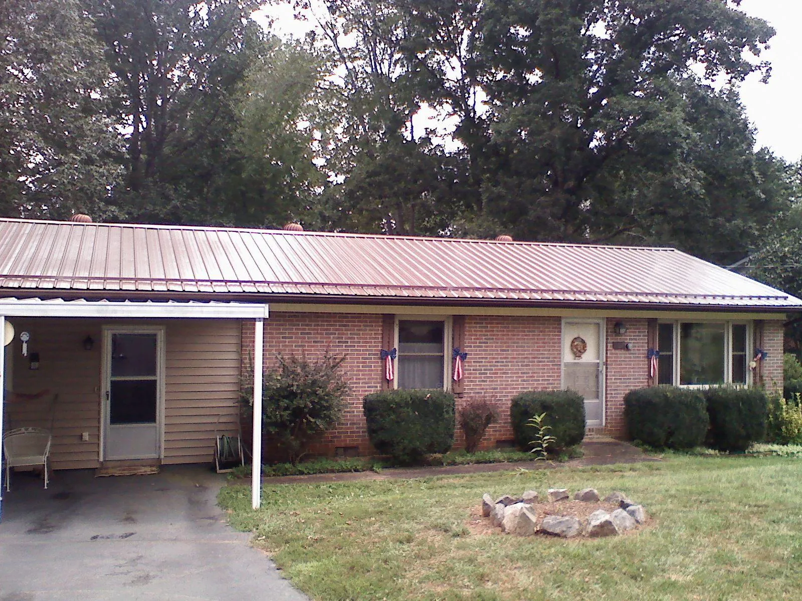 Bronze metal roof and carport on a brick ranch home — Roof Repair work by our crew in Crum Lynne